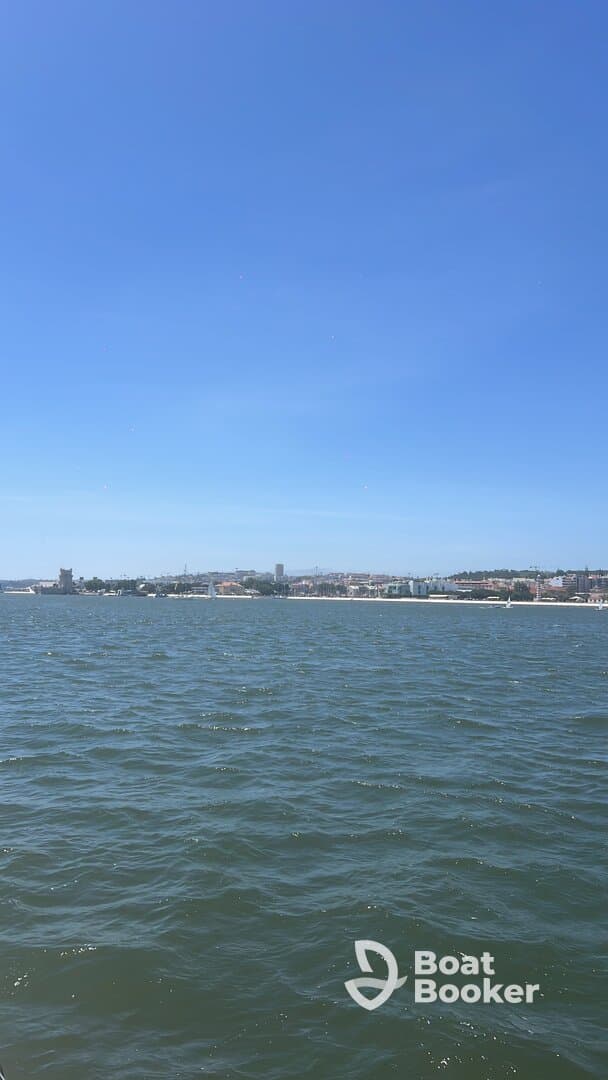 A distant view of a shoreline under a clear blue sky, with no identifiable subjects or activities.