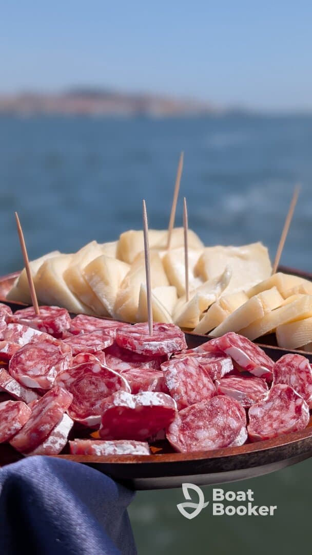 A beautifully arranged platter of charcuterie featuring assorted meats and cheeses, perfect for enjoying on a boat trip.