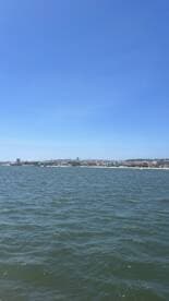 A distant view of a shoreline under a clear blue sky, with no identifiable subjects or activities.