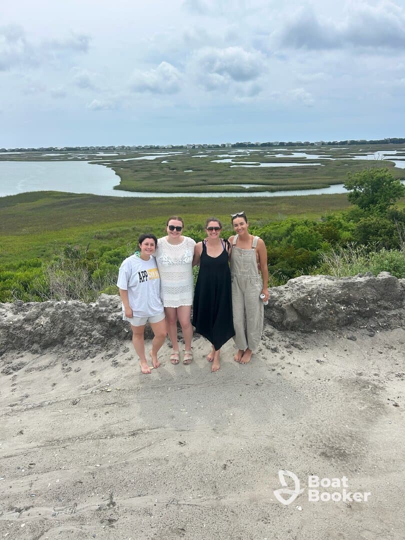 A group of friends poses together against a scenic backdrop of marshland, capturing a memorable moment during their outdoor adventure.