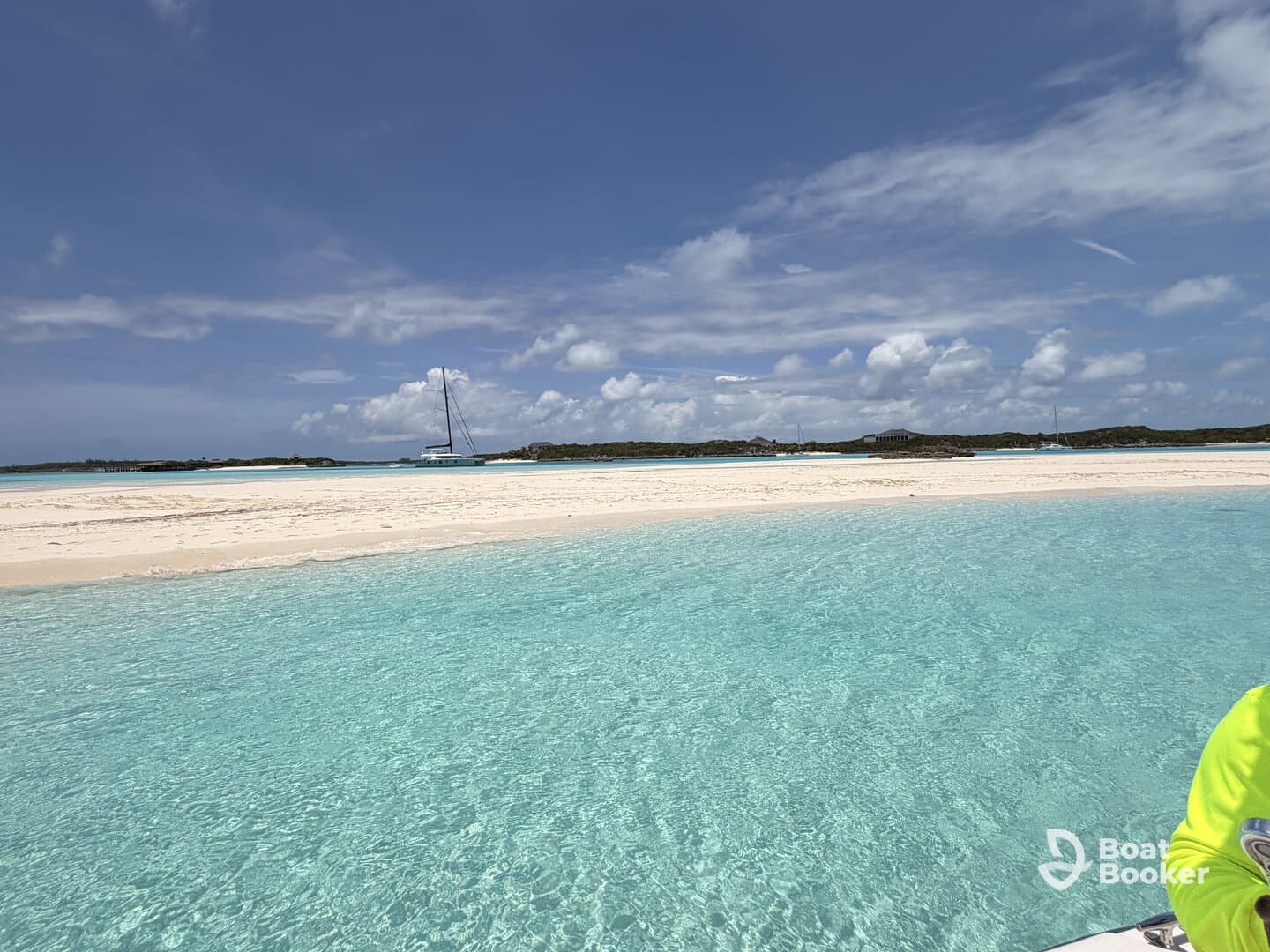 A stunning view of a secluded beach with crystal-clear turquoise waters and a distant sailboat, perfect for showcasing the beauty of island destinations.