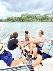 A family enjoys a scenic boat ride, pointing out sights along the water — perfect for creating lasting memories together.
