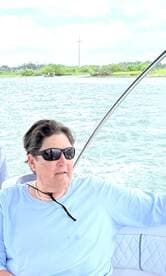 A woman enjoys a scenic boat ride, taking in the views of the water and surrounding greenery — a perfect moment for relaxation on the water.