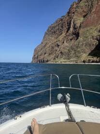 A scenic view from the bow of a boat, showcasing dramatic cliffs along the coastline — perfect for exploring beautiful landscapes on the water.