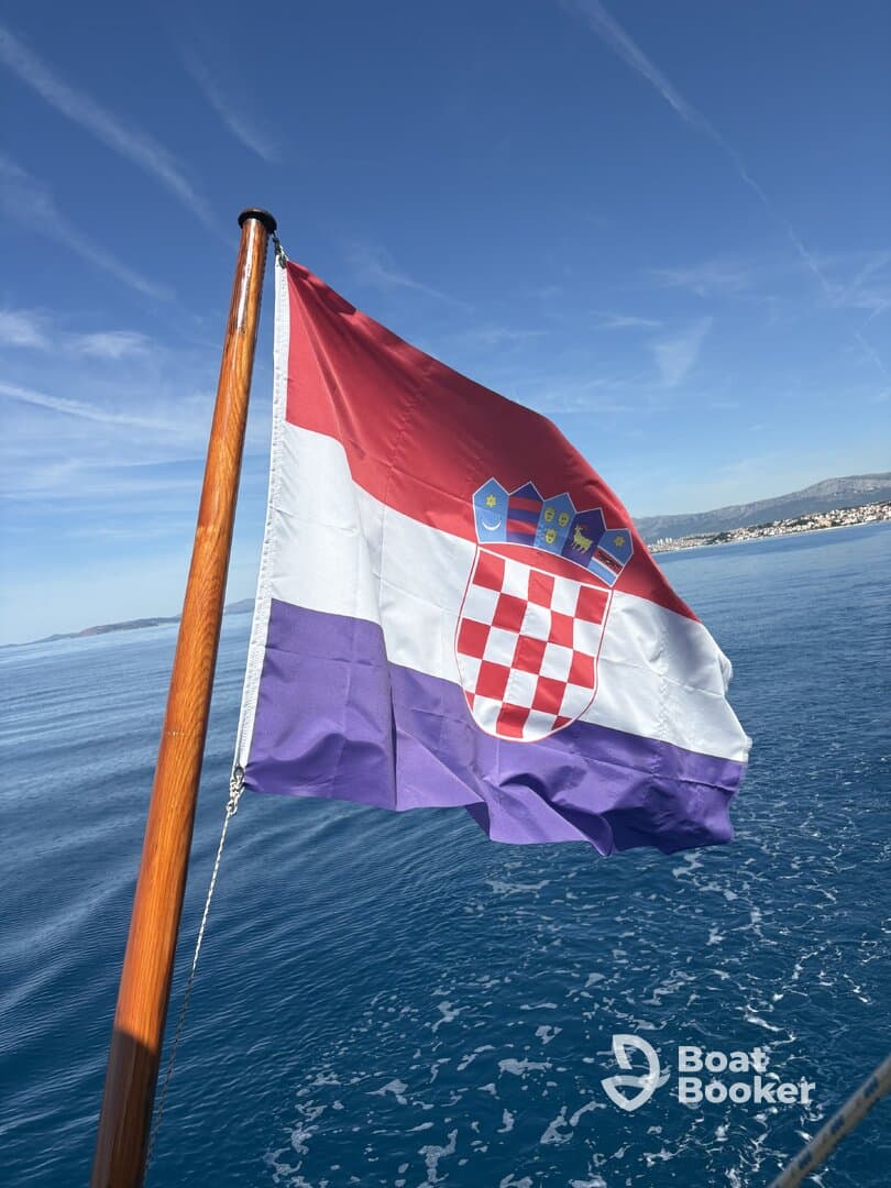 The Croatian flag waves proudly on a boat, set against a serene ocean backdrop — a symbol of maritime adventure in the beautiful Adriatic Sea.