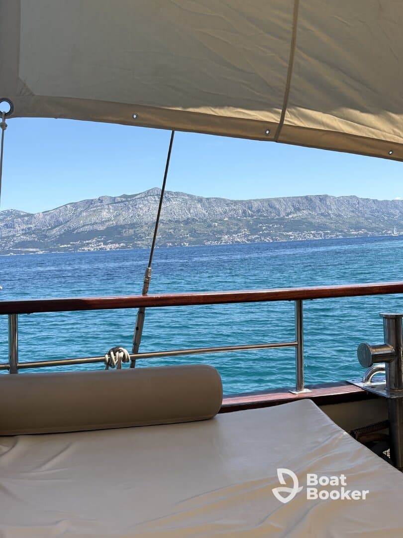 A serene view from the lounge area of a boat, showcasing the tranquil waters and distant mountains — perfect for relaxation and enjoying the scenery.