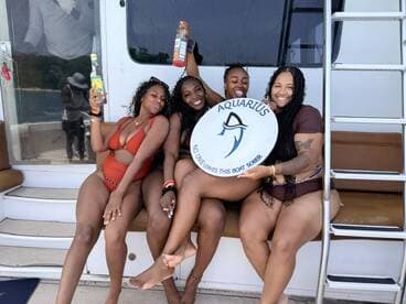 A lively group of friends enjoys a fun boat party, raising their drinks and celebrating together on the deck. Perfect for memorable outings and celebrations on the water.