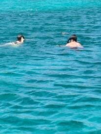 Two snorkelers explore the vibrant underwater world in crystal-clear waters, showcasing the excitement of aquatic adventures.