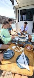 Guests enjoy a delicious onboard meal featuring a variety of dishes, perfect for enhancing the boating experience.