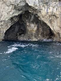 A stunning view of a natural cave along the coastline, surrounded by crystal-clear waters — a perfect spot for exploration and adventure.