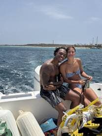 A happy couple enjoys a moment together on a boat, surrounded by the beautiful ocean — perfect for romantic getaways and adventurous outings.