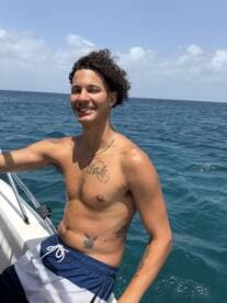 A young man enjoys a sunny day on a boat, showcasing the fun and relaxation of a day at sea.