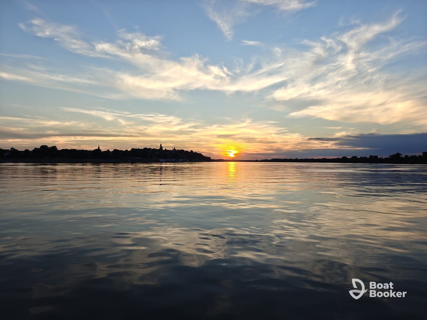 A stunning sunset reflects on calm waters, creating a picturesque scene perfect for evening boat trips and relaxation.