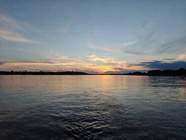 A stunning sunset over calm waters, showcasing the serene beauty of the coastline — perfect for peaceful evening boat rides.