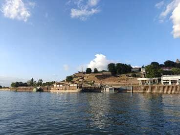 A picturesque view of a harbor with historical structures and lush greenery, perfect for exploring scenic waterways.