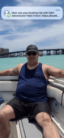 A man enjoys a relaxing moment on a boat, surrounded by beautiful turquoise waters — a perfect snapshot of a memorable boating trip.