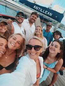A joyful group of friends captures a fun selfie aboard the boat 'Antillean,' showcasing their excitement and camaraderie during a memorable outing on the water.