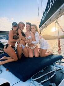 A joyful group of friends poses together on a yacht at sunset, capturing a perfect moment of celebration and camaraderie on the water.