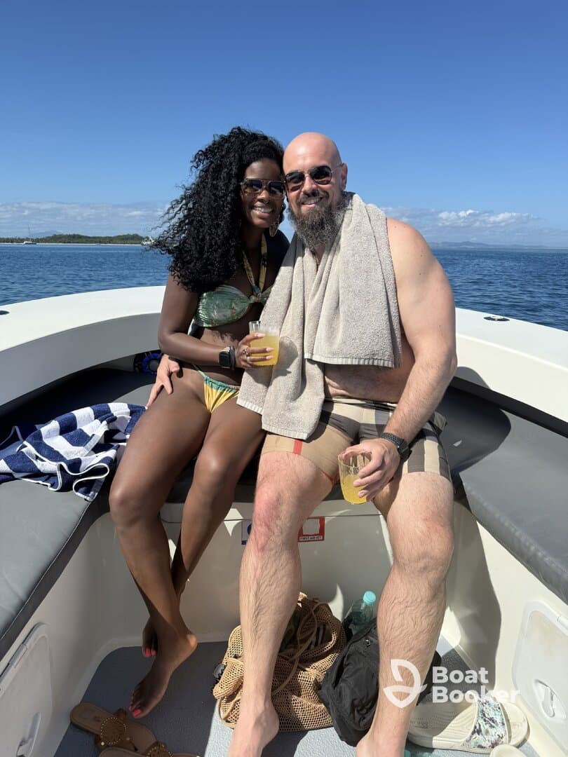 A couple enjoys refreshing cocktails on a sunny day aboard a boat, perfect for celebrating special moments on the water.