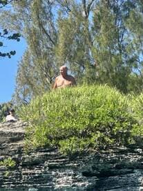 Two individuals are seen on a rocky outcrop, enjoying the natural surroundings — a perfect setting for outdoor adventures and exploration.
