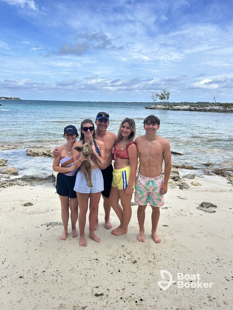 A joyful group of friends poses on the beach, showcasing a fun day in the sun with a dog — perfect for family outings and beach adventures.