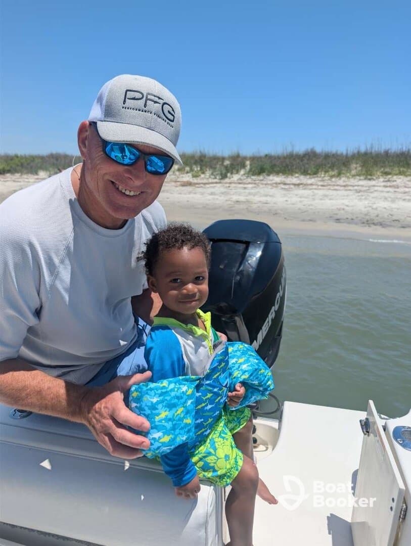 A joyful moment captured on a boat with a child and adult, both wearing life jackets, showcasing a fun family outing on the water.