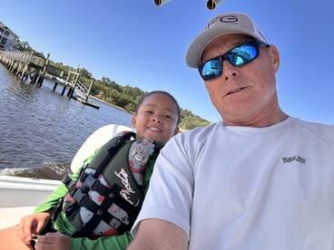 A joyful moment captured on a boat with a child and adult, showcasing a fun family outing on the water.