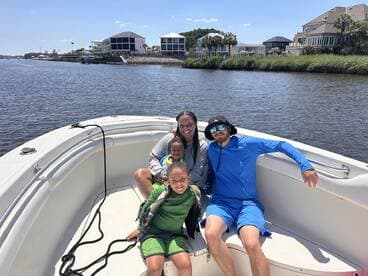 A joyful family enjoys a sunny day on the boat, capturing fun moments together on the water — perfect for family outings and adventures.