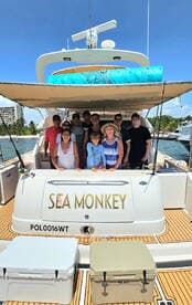 A cheerful group poses aboard the 'Sea Monkey' boat, capturing a memorable moment together — perfect for family outings or group celebrations on the water.