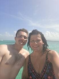 A joyful moment captured as a mother and son enjoy a swim in the beautiful turquoise waters, perfect for family bonding during a tropical getaway.