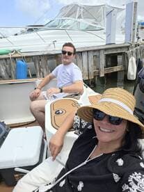 A couple enjoys a sunny day on a boat, capturing the essence of relaxation and friendship on the water.