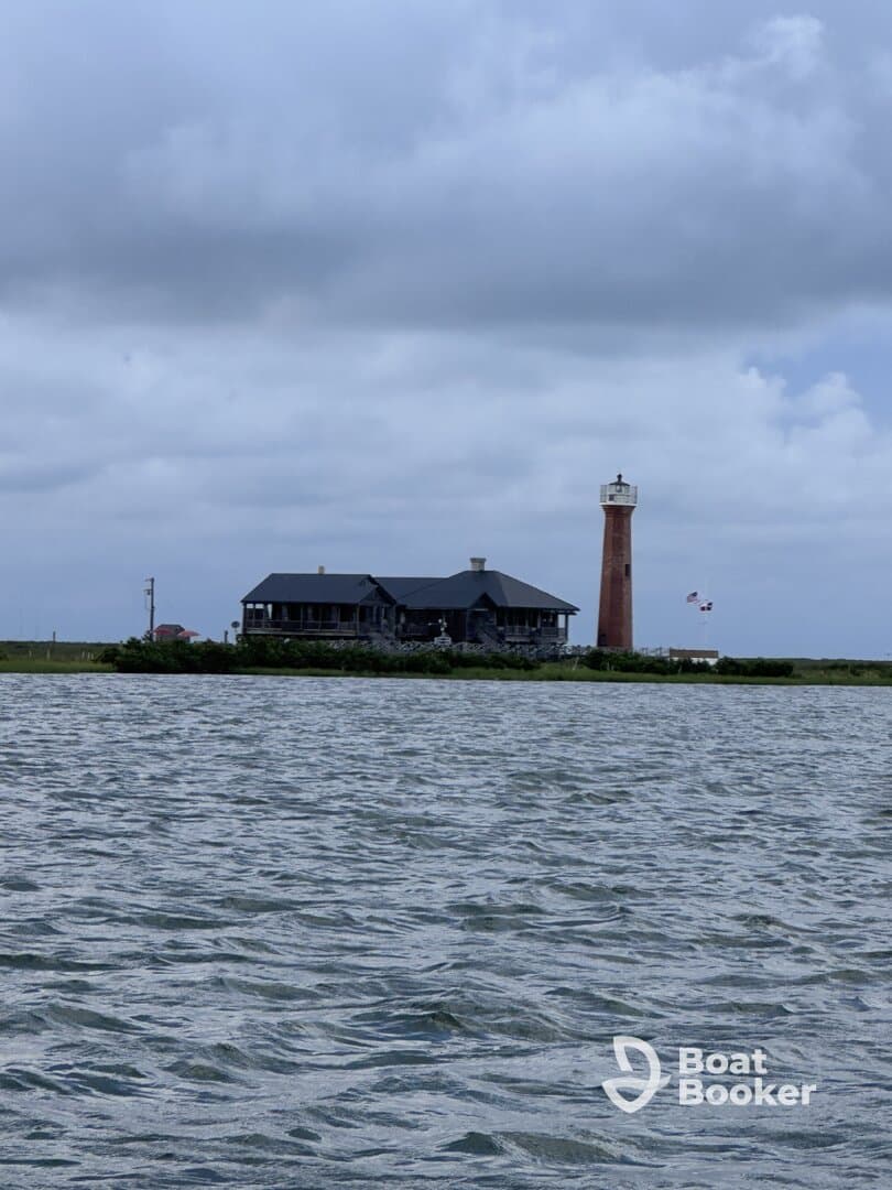 A scenic view of a lighthouse and a charming building along the shoreline, capturing the essence of coastal landmarks and tranquil waters.