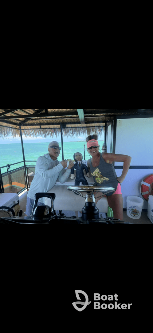 A joyful group poses with a fun prop aboard a boat, showcasing a lively atmosphere perfect for memorable trips on the water.