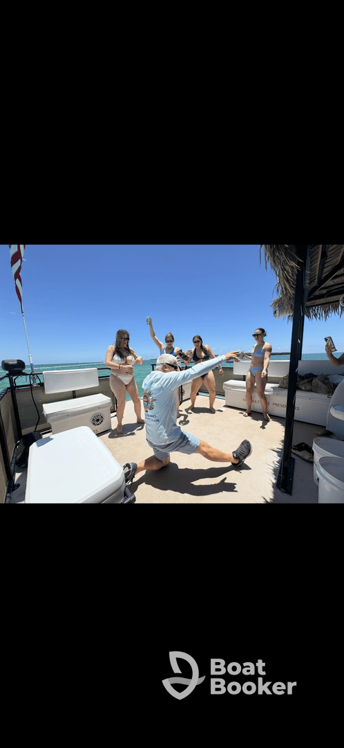 A lively group enjoys a fun moment on a boat, dancing and celebrating under the sun — perfect for unforgettable summer outings.