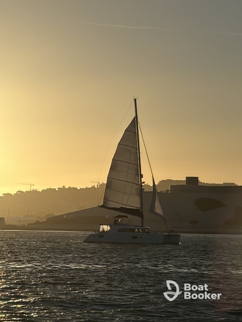 A serene sunset view of a sailboat gliding through the water, showcasing the beauty of sailing at dusk.