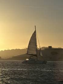 A serene sunset view of a sailboat gliding through the water, showcasing the beauty of sailing at dusk.