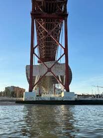 A view of a large structure from below, with water in the foreground. The image lacks clarity and focus.