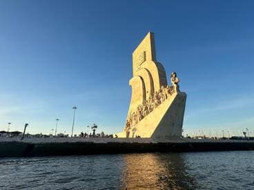 A stunning view of a prominent landmark along the waterfront, with people enjoying the scenic surroundings — perfect for sightseeing and cultural exploration.