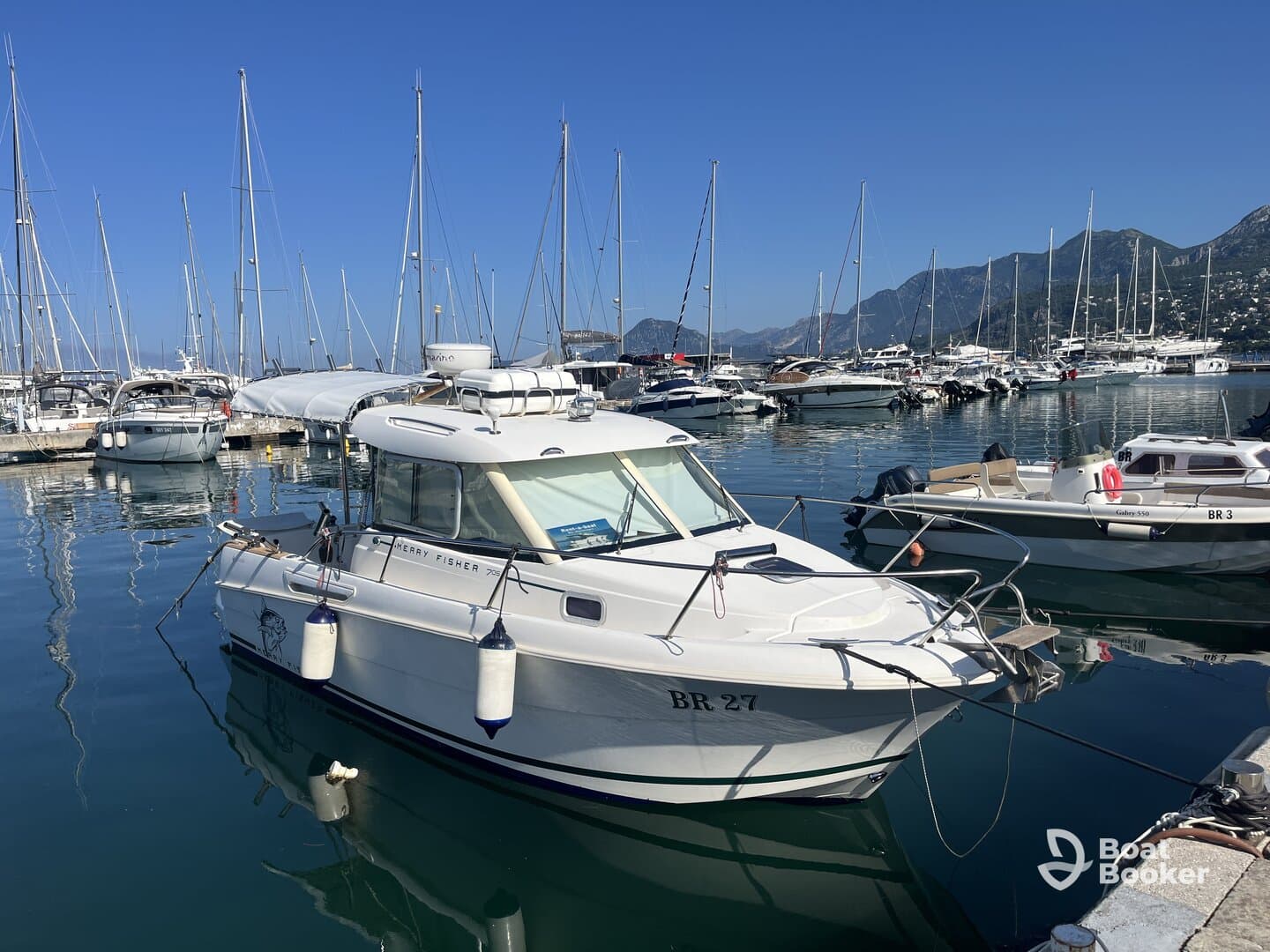 A pristine Merry Fisher boat docked in a marina, surrounded by other vessels and reflecting the clear blue sky — ideal for fishing or leisure outings.