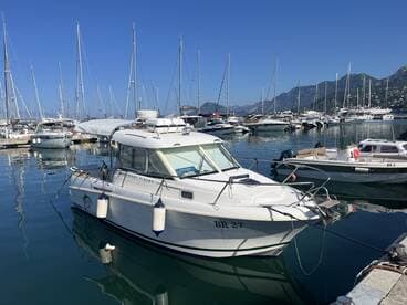 A pristine Merry Fisher boat docked in a marina, surrounded by other vessels and reflecting the clear blue sky — ideal for fishing or leisure outings.