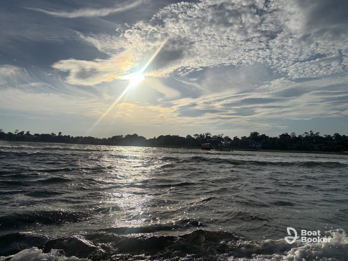 A scenic view of the water and sky, capturing the sun's rays, but lacks clarity and identifiable subjects.