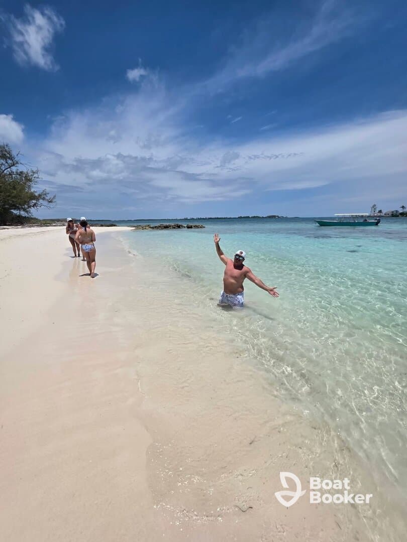 A group of friends enjoys a sunny day at the beach, with one person playfully splashing in the water — a perfect sandbar stop for fun and relaxation.