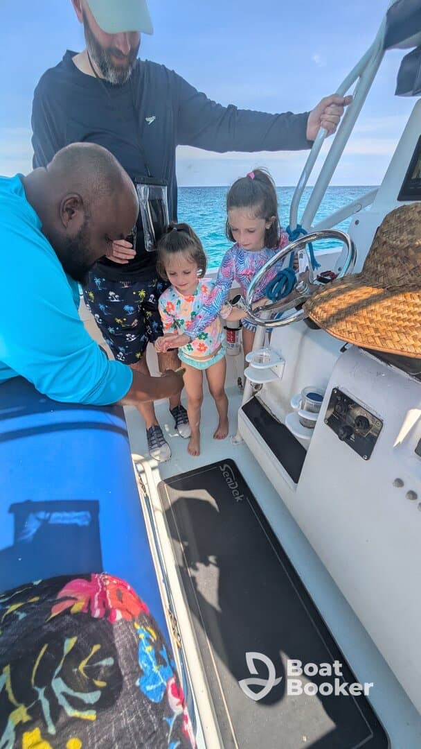 A joyful moment on a boat as two young girls interact with an adult, showcasing family fun and bonding on the water.