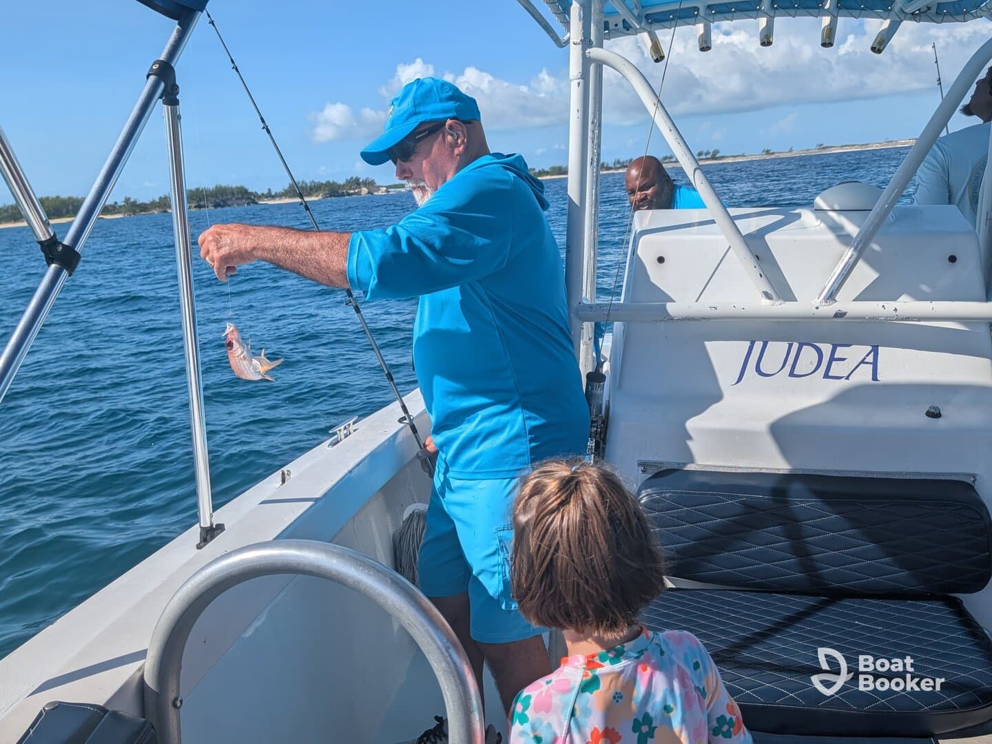 A joyful moment as a child watches an adult proudly display a freshly caught fish while fishing on a boat — a perfect family adventure on the water.