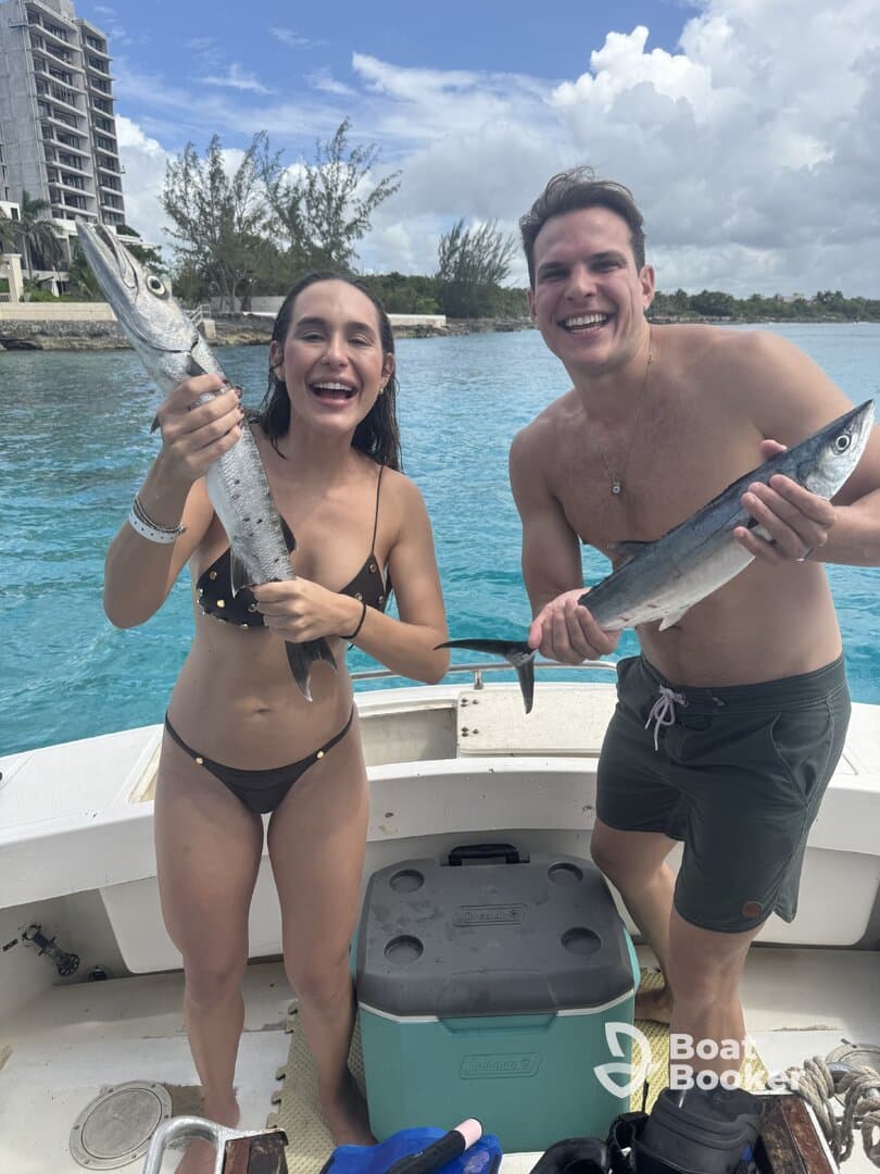 A joyful couple proudly displays their fishing catch while enjoying a day on the water — a perfect moment for fishing enthusiasts and adventure seekers.