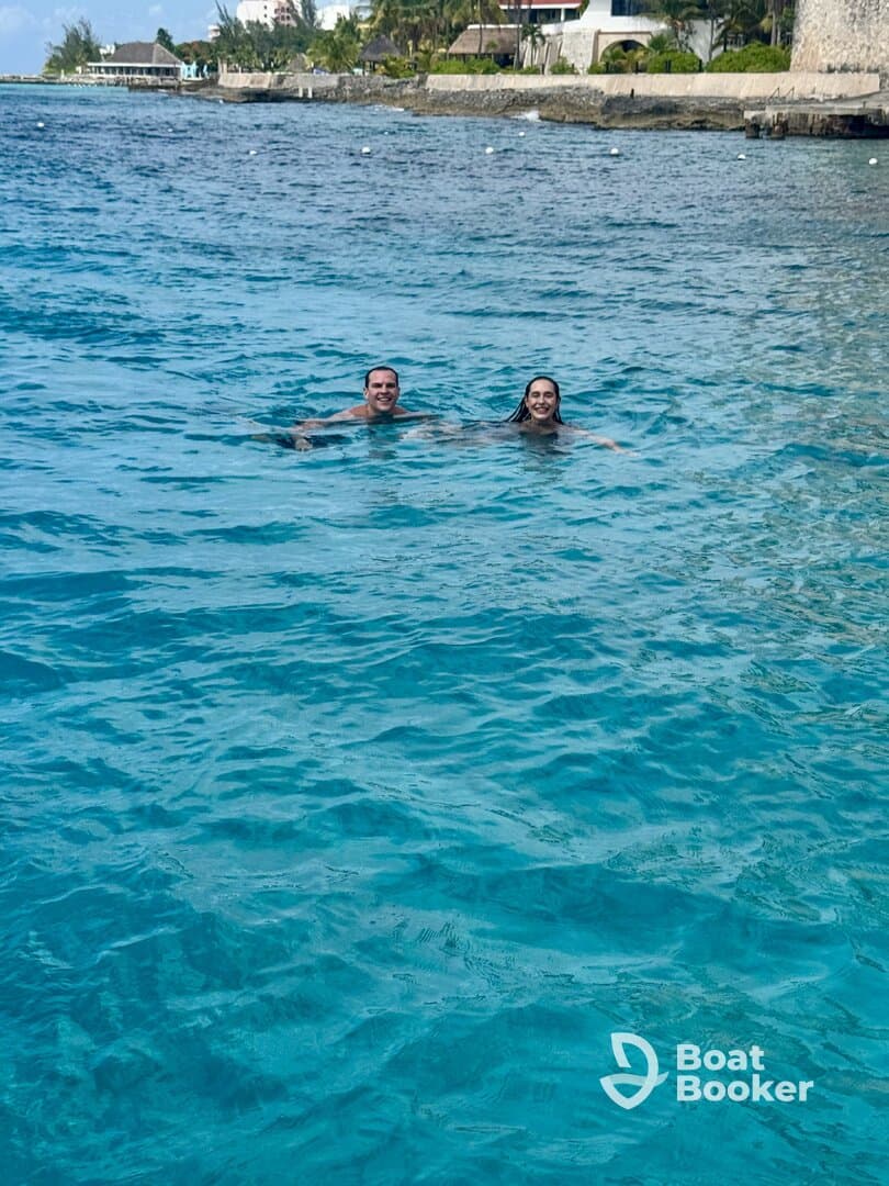 A couple enjoys a refreshing swim in crystal-clear waters, showcasing the perfect tropical getaway experience.