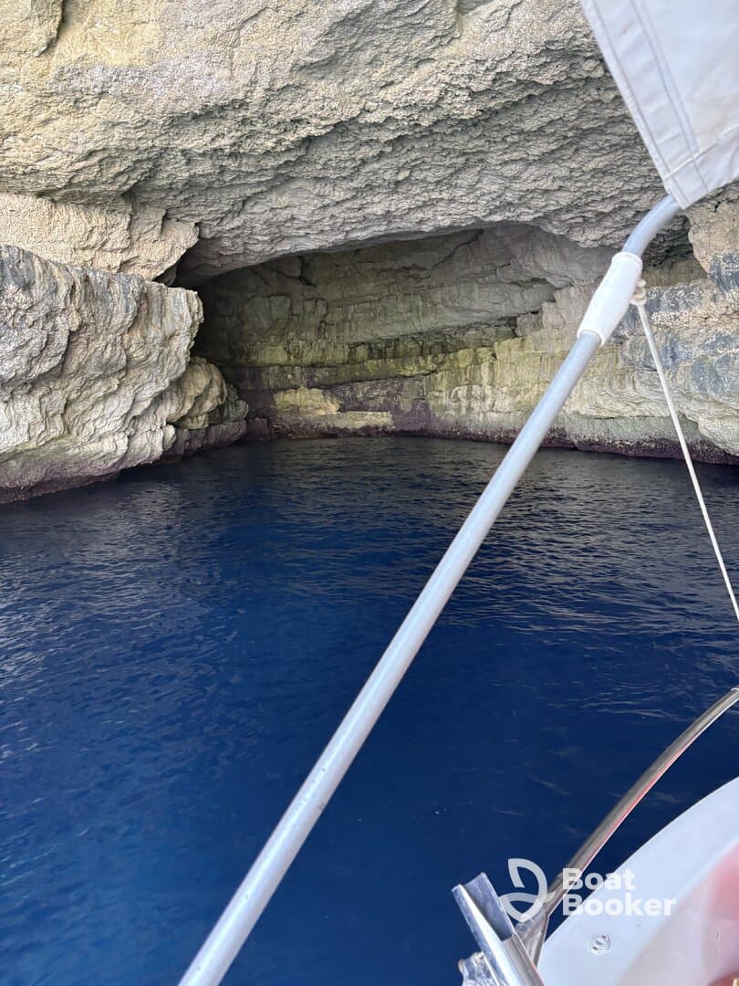 A stunning view of a cave entrance from a boat, showcasing the vibrant blue water and textured rock formations — perfect for exploring hidden gems on your boating adventure.