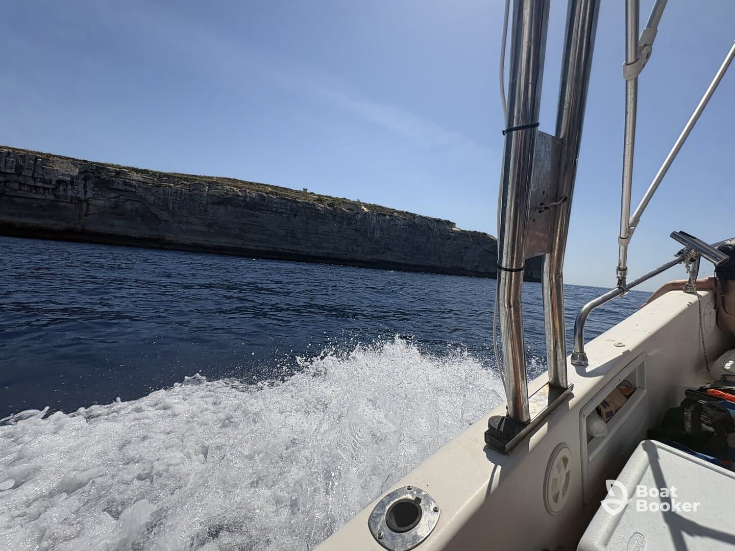 A scenic view from a boat underway, showcasing the beautiful cliffs and open water — perfect for adventure seekers exploring coastal landscapes.