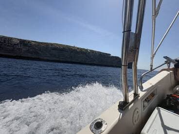 A scenic view from a boat underway, showcasing the beautiful cliffs and open water — perfect for adventure seekers exploring coastal landscapes.