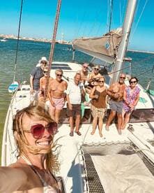 A joyful group of friends enjoys a sunny day aboard a yacht, celebrating with drinks and smiles — perfect for memorable outings on the water.